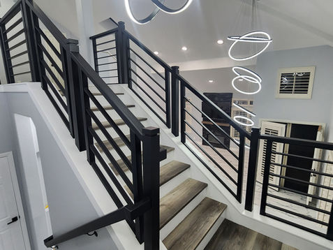 Modern staircase with sleek black railings and spiral lights.