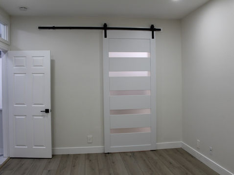 White sliding barn door on a track in room.