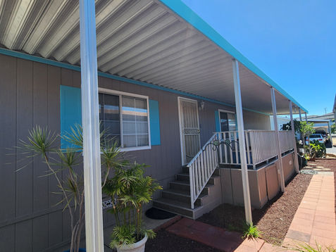 Mobile home with blue trim and covered porch.