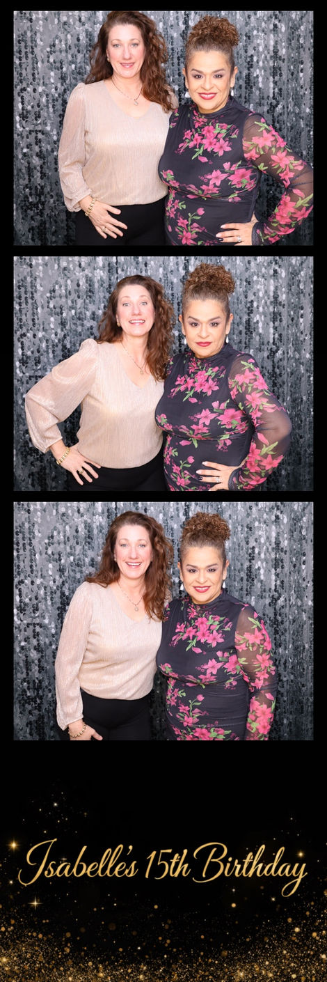 Two women posing in front of a sparkly backdrop.