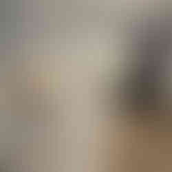 Elegant kitchen with white and gold marble-look countertops, under-cabinet lighting, and black stainless steel appliances.