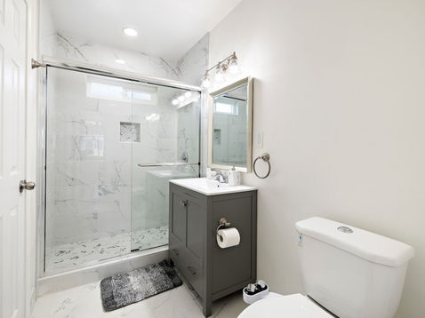 Modern bathroom with glass shower and sleek vanity.