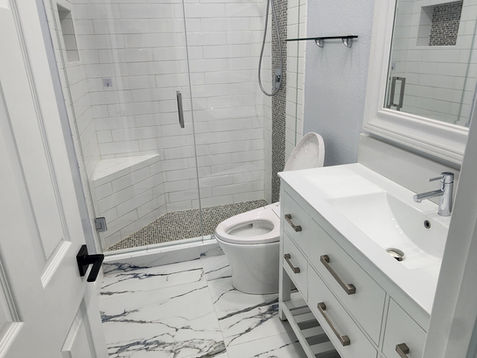 Modern bathroom with marble floor and glass shower.