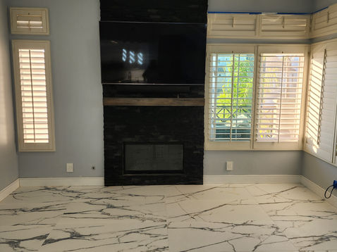 Living room with fireplace and large windows.