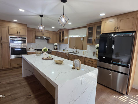Modern kitchen with wooden cabinets and white countertops.