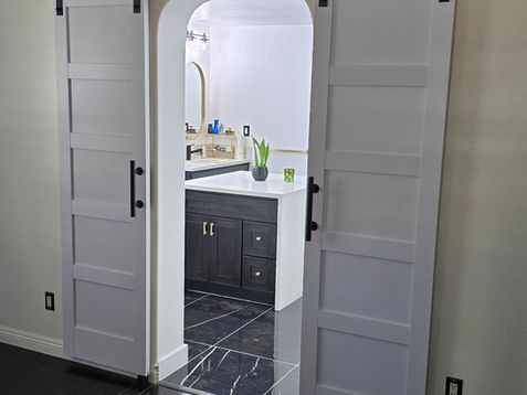 White sliding barn doors leading to a modern kitchen.