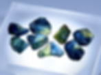 rough parti color sapphire on a light table, clearly delineated zones of blue and yellow visible.