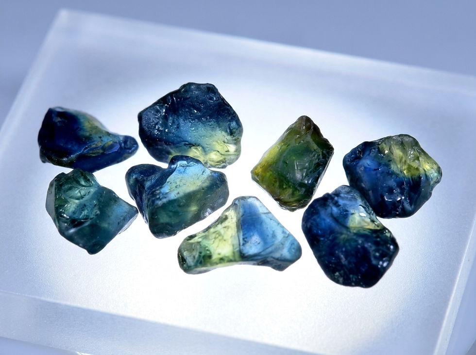 rough parti color sapphire on a light table, clearly delineated zones of blue and yellow visible.