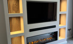 A bespoke media wall with shelving, acoustic slat wall panelling, led lighting a Gazco eReflex 135RW fire in Chelmsford.