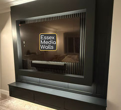 A media wall with TV frame, acoustic slat wall panelling, bespoke floating worktop, tv back lighting.