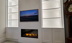 bespoke media wall with a cupboard to the side and a Gazco eReflex 110RW Fire in Witham.