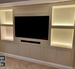 A bespoke media wall with shelving, cupboards and led lighting.