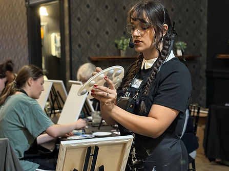 Photo of Nala Heer, owner of Zara Studio & Co., instructing a painting class