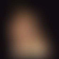 Child wearing a cardboard robot helmet with a yellow ball antenna, gazing upward. Dark background, evokes curiosity and imagination.