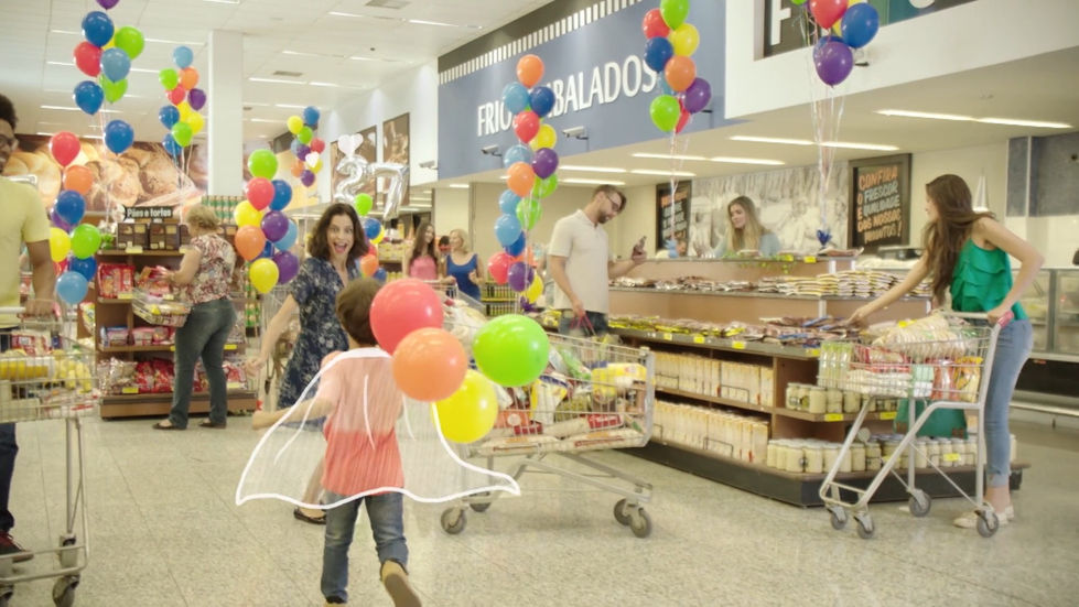 Criança correndo pelo supermercado com capa desenhada