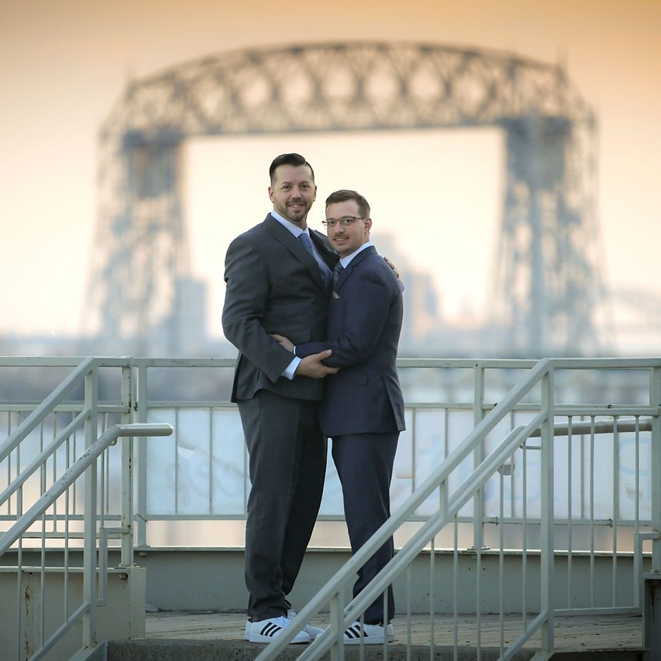 Grooms embrace near water