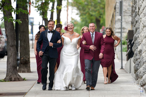 LGBTQ+ wedding party walks towards bride for their first look