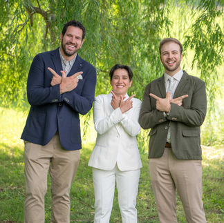 A joyful moment from a same-sex micro wedding, featuring a couple in elegant attire. They are surrounded by intimate, natural settings or a small, personal ceremony setup. The focus is on the couple's connection and love, with soft lighting highlighting the intimate atmosphere