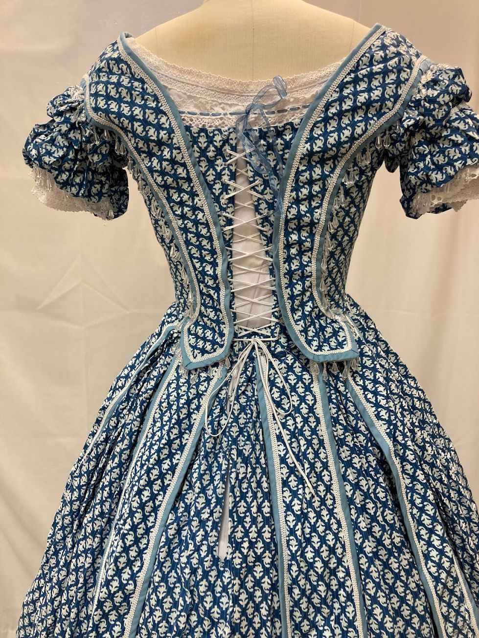 A back view of the blue dress, it laces up the back and the designs from the front continue to the back