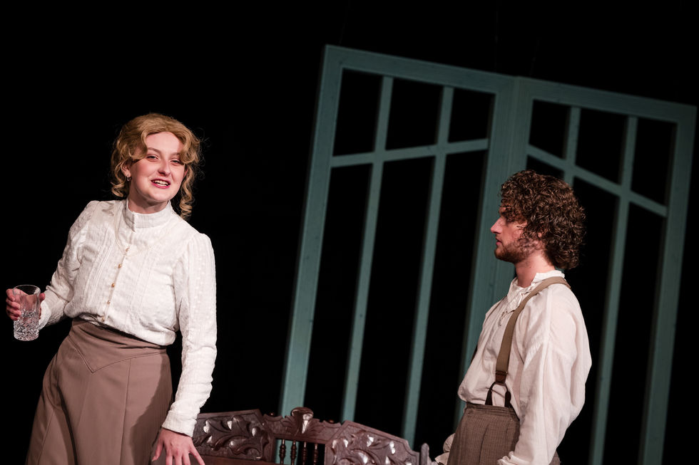 The blouse features pintucks and a faux button placket as well as some decorative trim