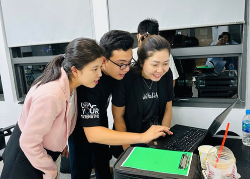 Ba người đang làm việc nhóm trên máy tính xách tay