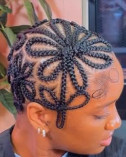 Intricate flower-patterned braids on a Braided Baldie.