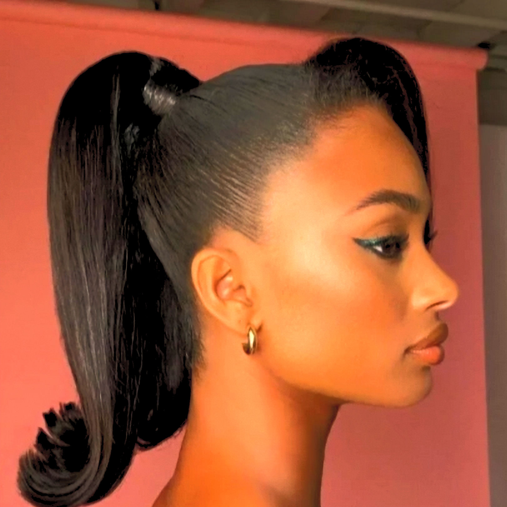 Woman with a high, sleek ponytail against a white background