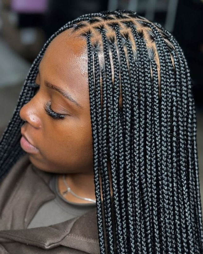 Small size knotless braids on a woman with neat parts.