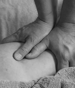 Man giving a massage to a leg with two h