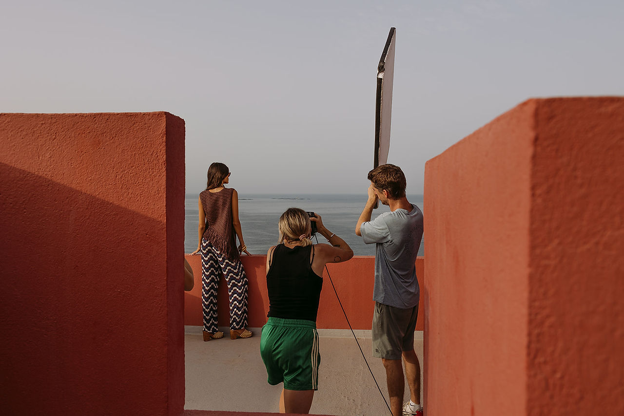 model looks at the sea whilst photographer shoots