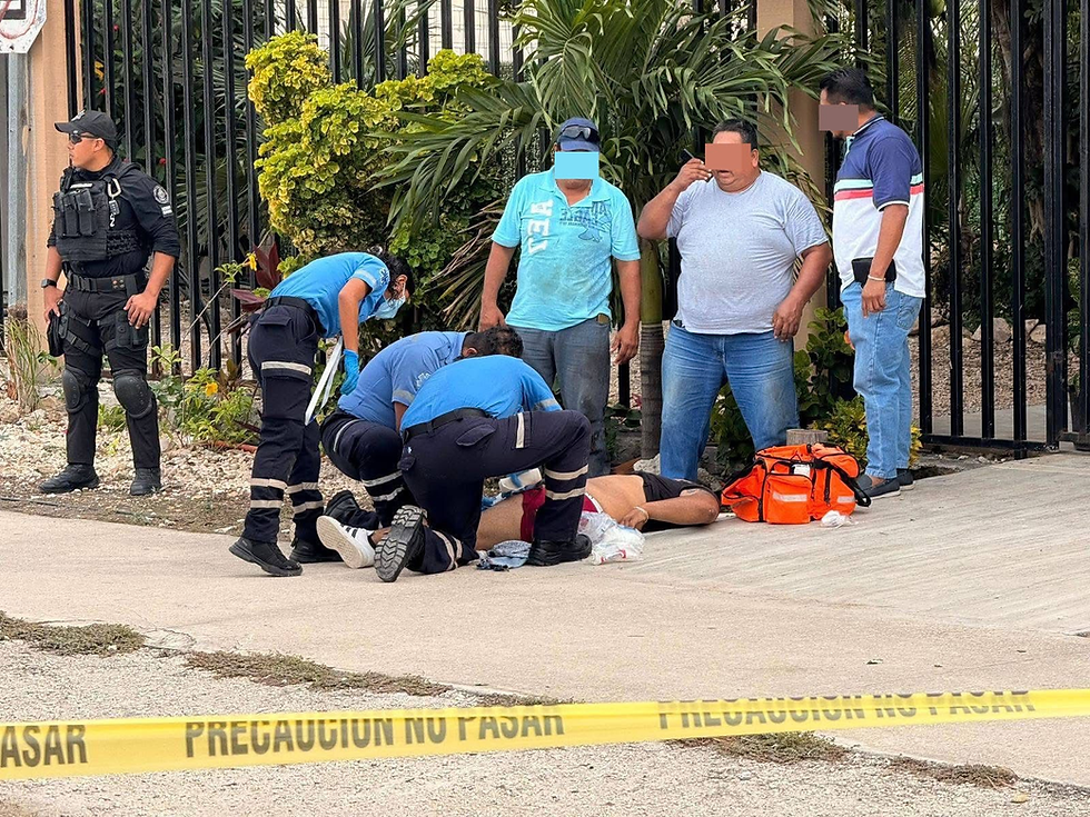 Tendido en el pavimento, el hombre que recibió varios disparos, recibe los primeros auxilios antes de ser llevado al hospital, donde se reporta como muy delicado su estado de salud.