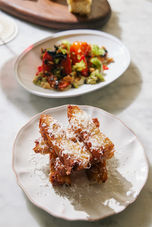 Plates of food, with several dishes ready for consumption, on a table top.