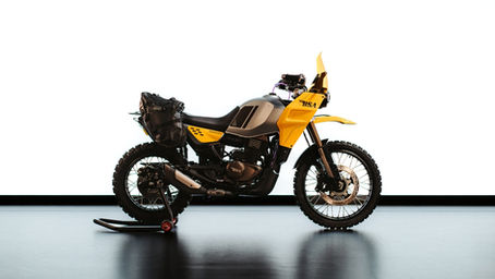 Yellow and black motorcycle on a stand against a white background. Bold "BSA" logo visible. Simple and sleek design.