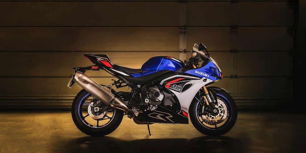 Blue and white Suzuki motorcycle in a dim garage setting. Emphasizes sleek design and bold colors; logos and text visible on the body.