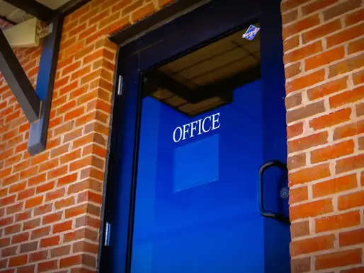 Blue office door in a brick commercial building