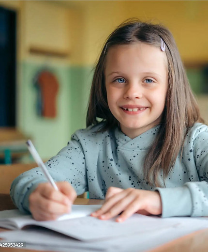 Photo of girl, completing a dyslexia assessment and smiling