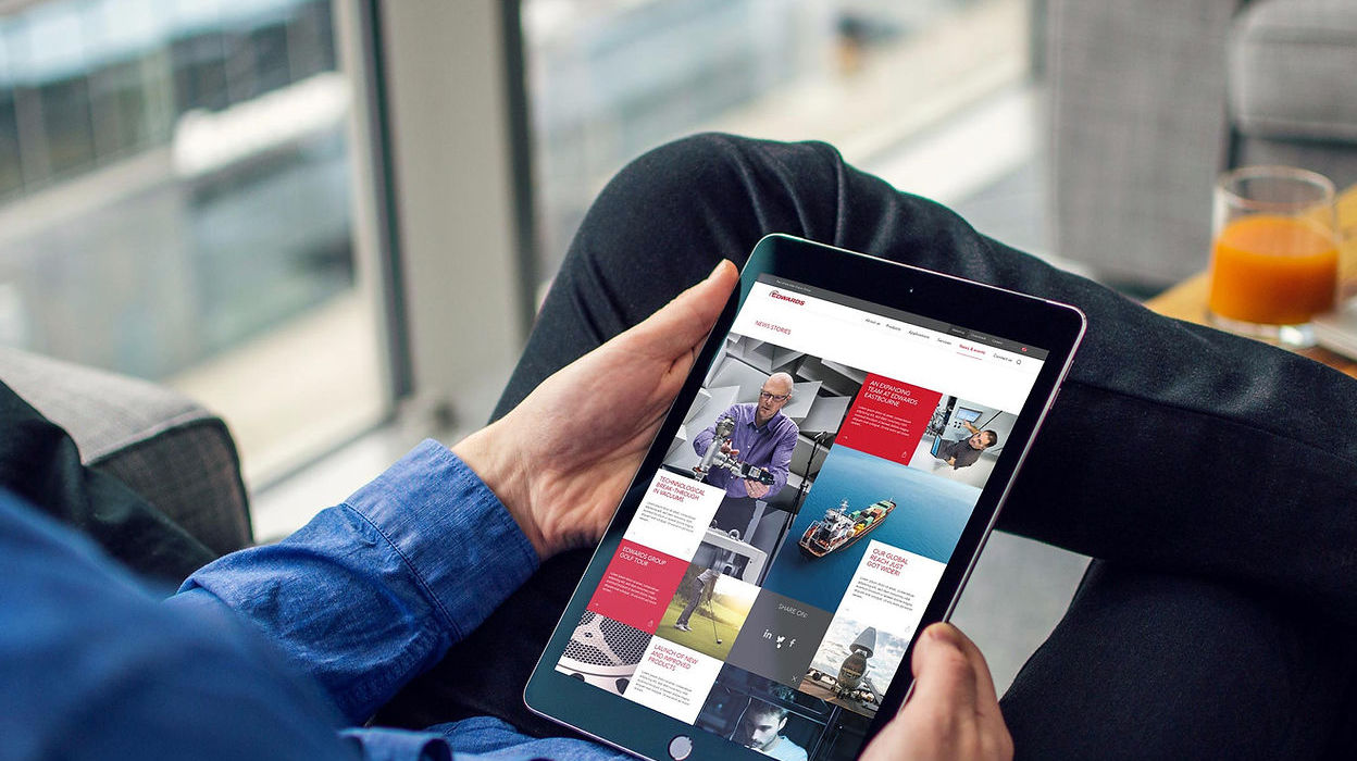 Person holding tablet with Edwards website design displayed