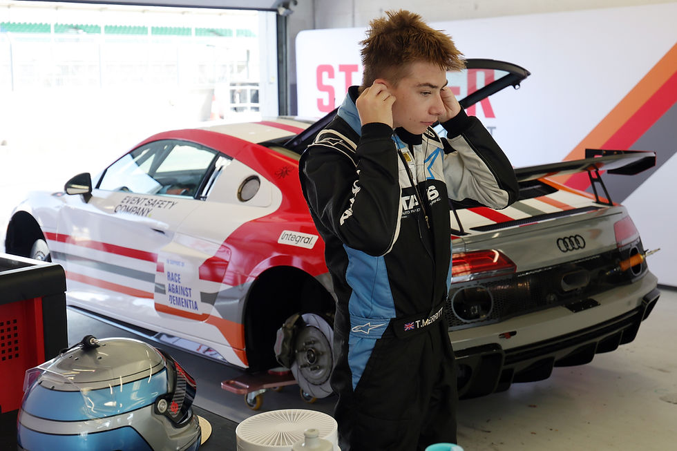 Driver Thomas Merritt preparing next to his Audi race car