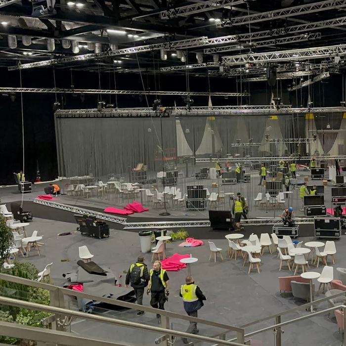 Large event space after an event, debris and workers visible in the area