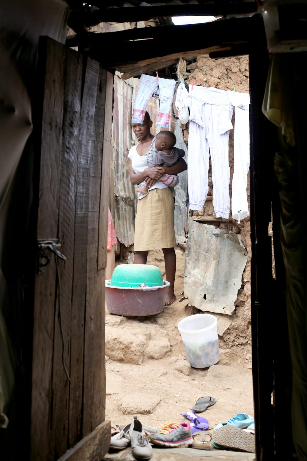 Mother holding baby in impoverished home