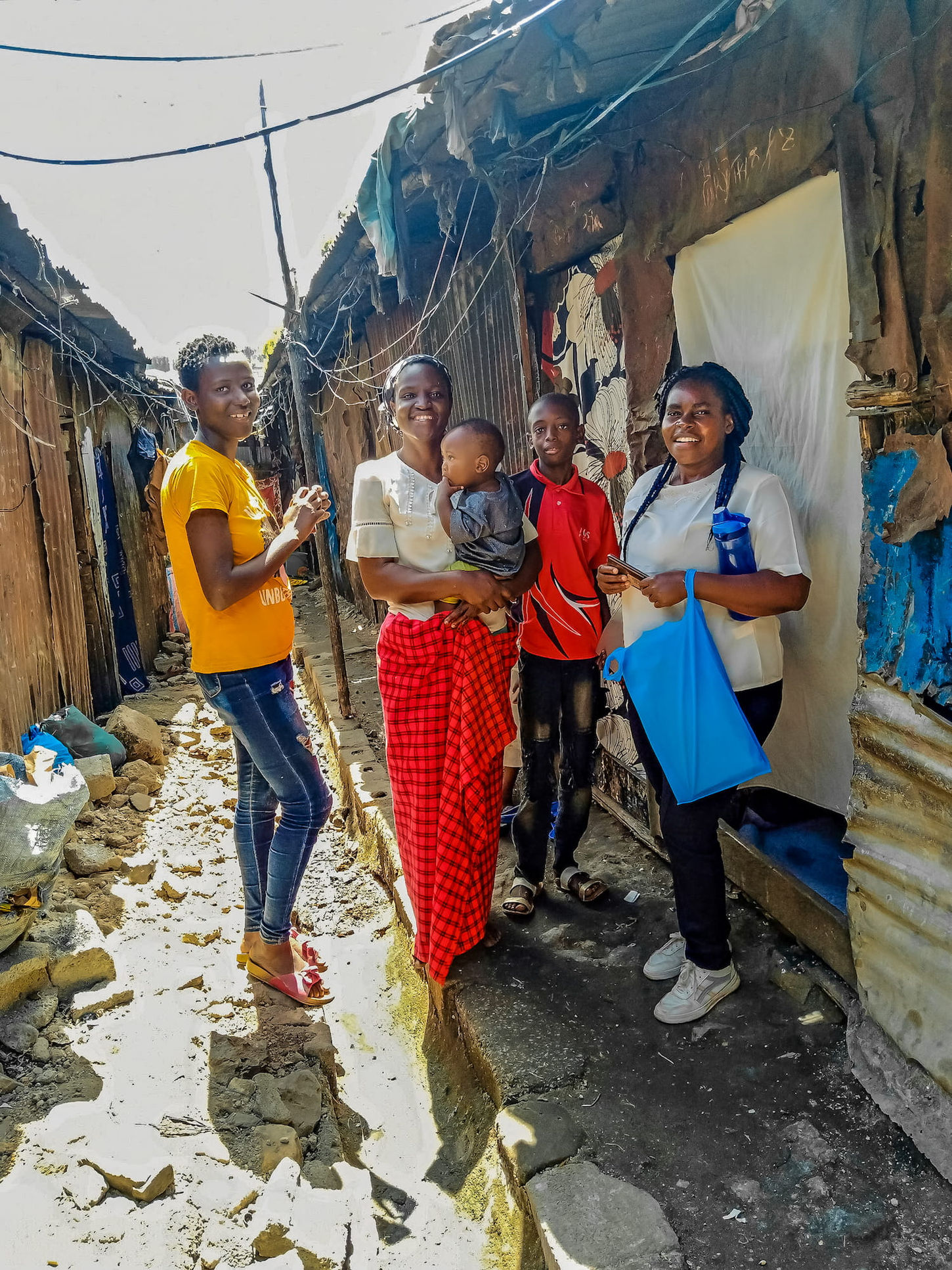 Smiling women and children in a slum