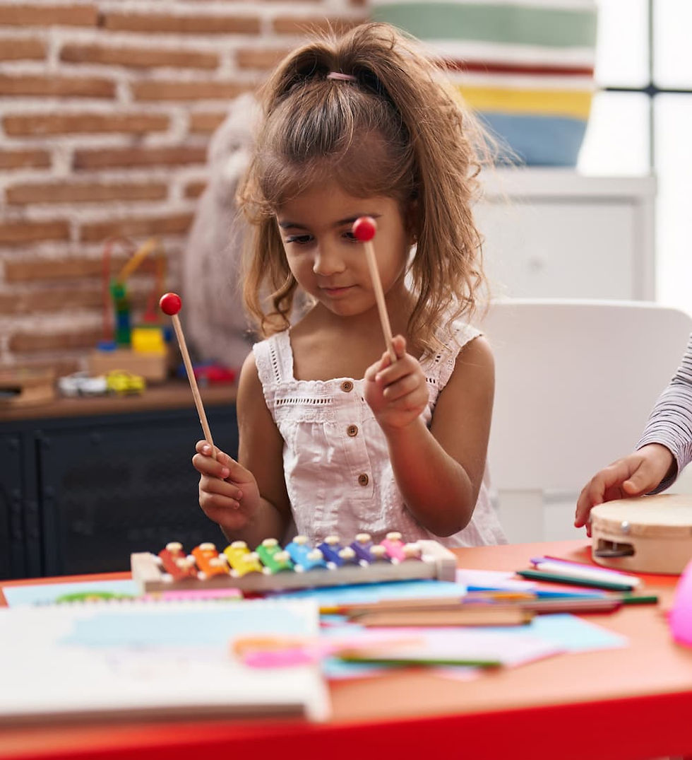 Girl playing xylophone, colorful art supplies