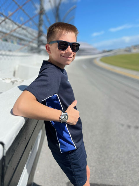 Smiling Thomas at racetrack, thumbs up