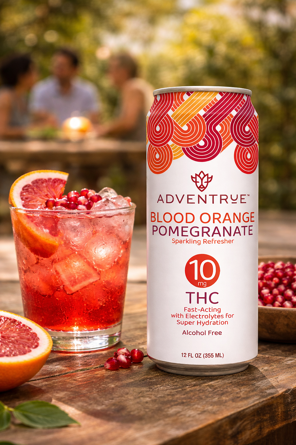 AdvenTrue Blood Orange Pomegranate 10mg THC sparkling refresher can beside a vibrant citrus cocktail with blood orange slice and pomegranate garnish on a wooden table.