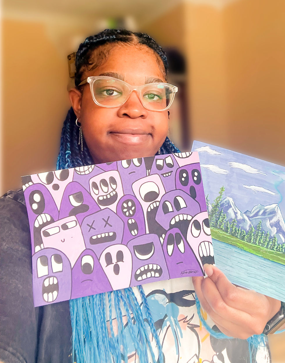 Portrait of Lydia Johnson, UK illustrator and founder of L'Graw Studios, holding two of her original illustrations.