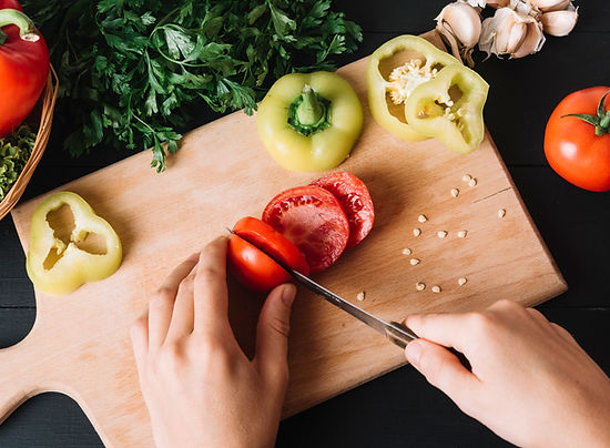 elevated-view-human-hand-slicing-fresh-red-tomato-wooden-chopping-board.jpg