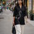 Thumbnail: Woman walking in embroidered black cotton short top and white palazzo pants, holding black handbag in casual outdoor setting.