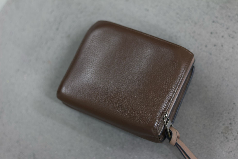 ブラウンレザーのLOEWEウォレット。中央に鮮やかな青のベルトがアクセントとして施されている。