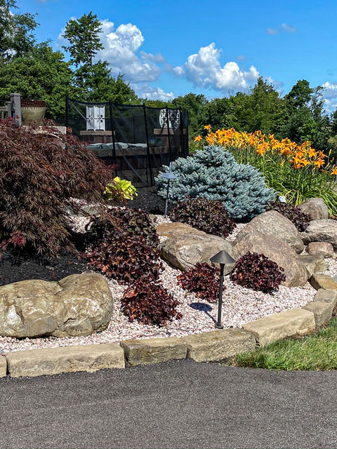 natural landscape design using boulders, decorative gravels, mulch and plants in Green, Ohio.