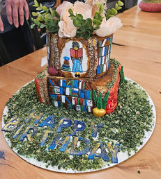 Library themed birthday cake with floral topper.